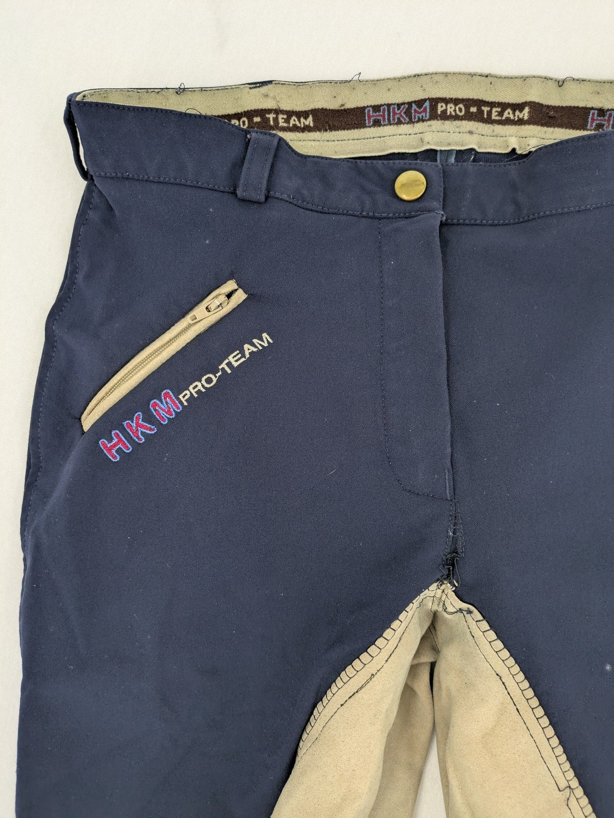 H&KM beige riding pants with dark blue full seat and front zippers.