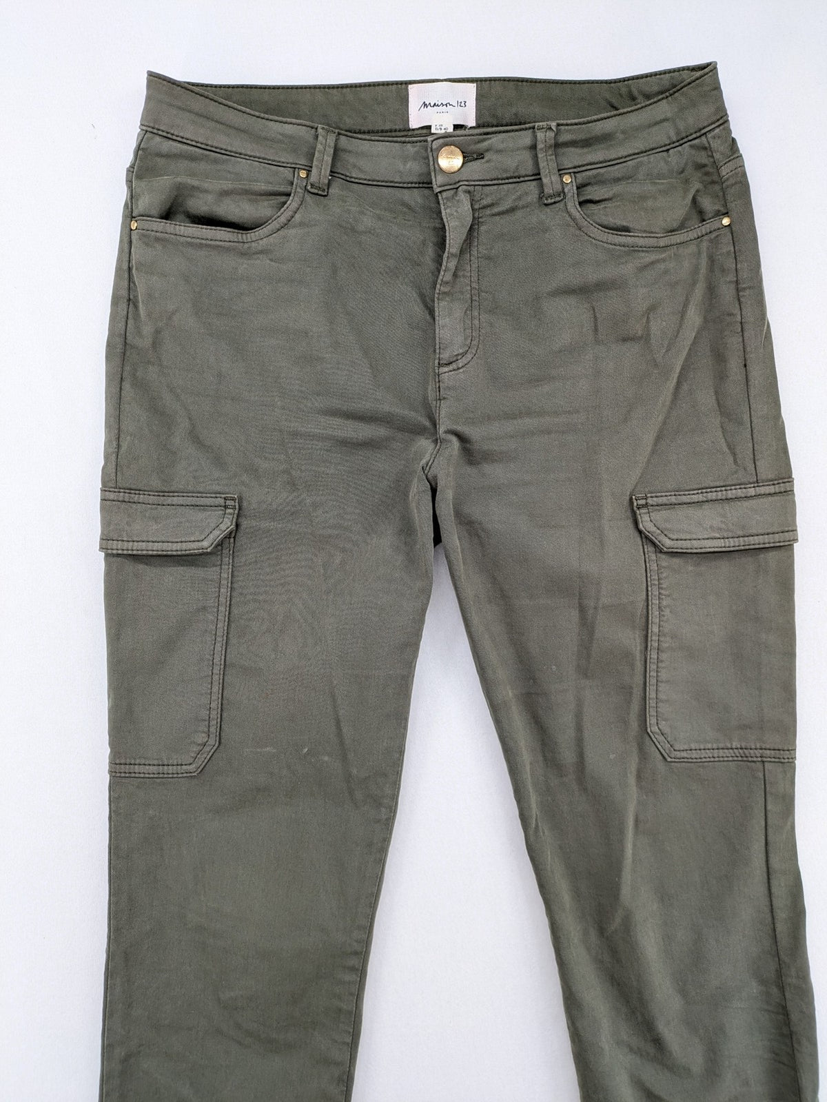 Maison 123 green cargo pants with ankle zippers and gold metal details.