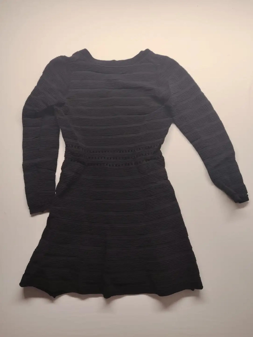 Supertuga black ribbed dress with V-neck, long sleeves, and pointelle detail at waist.
