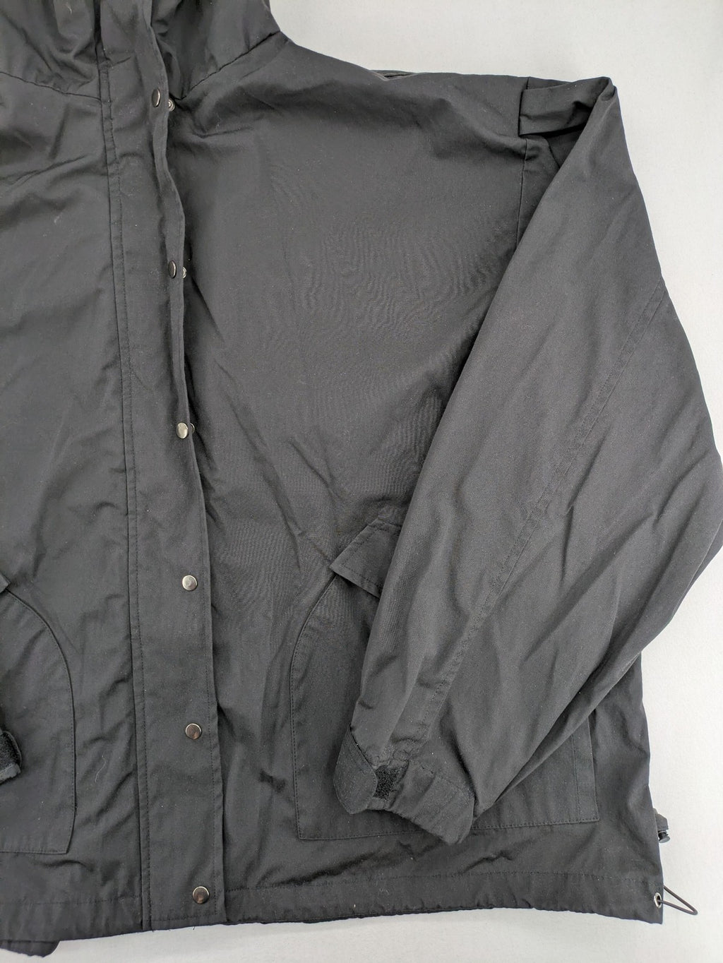 Hypnotism grey windbreaker jacket with hood, snap buttons, and zip closure.