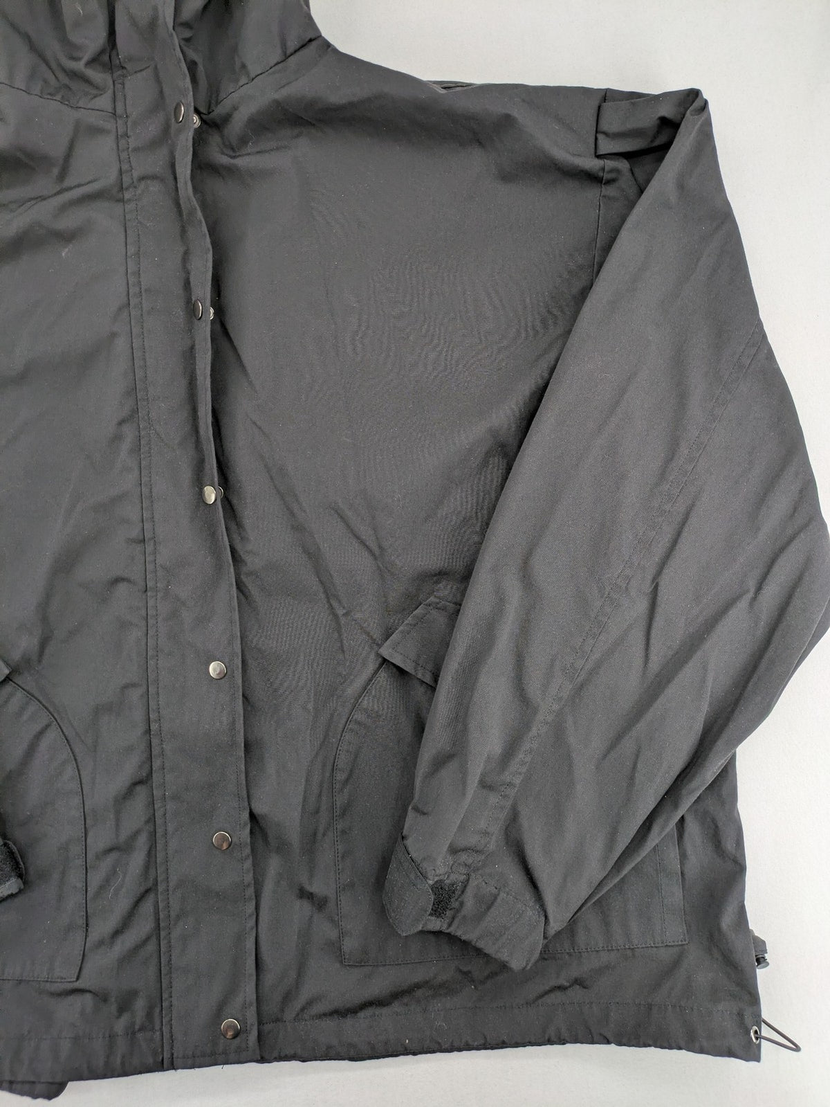 Hypnotism grey windbreaker jacket with hood, snap buttons, and zip closure.