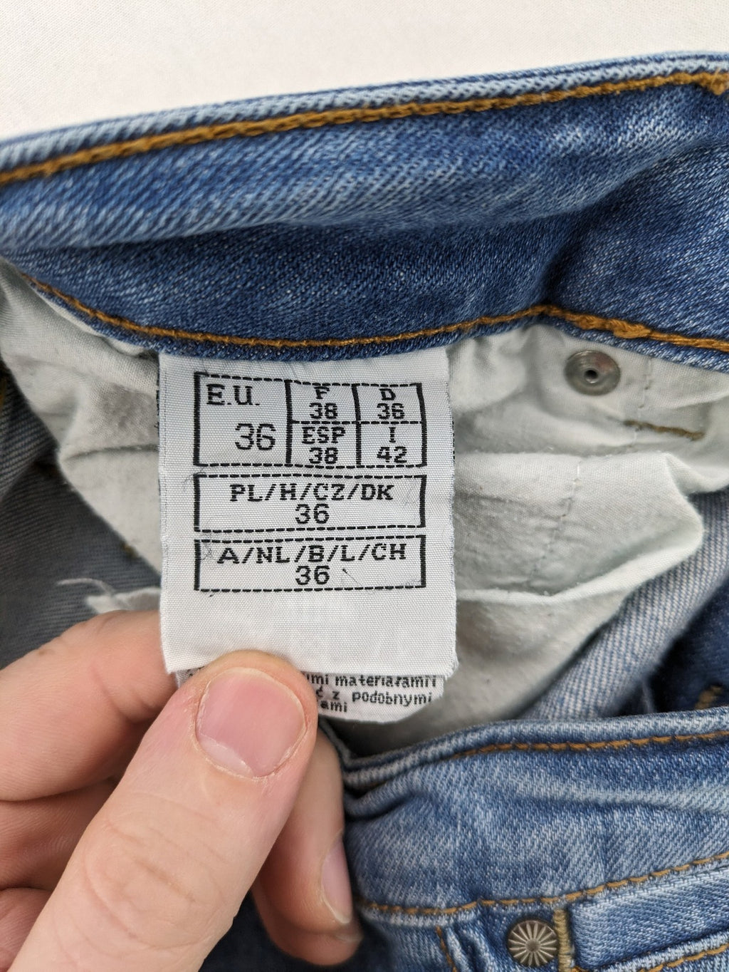 Denim blue straight jeans low rise bootcut with classic 5-pocket design and subtle rivets.