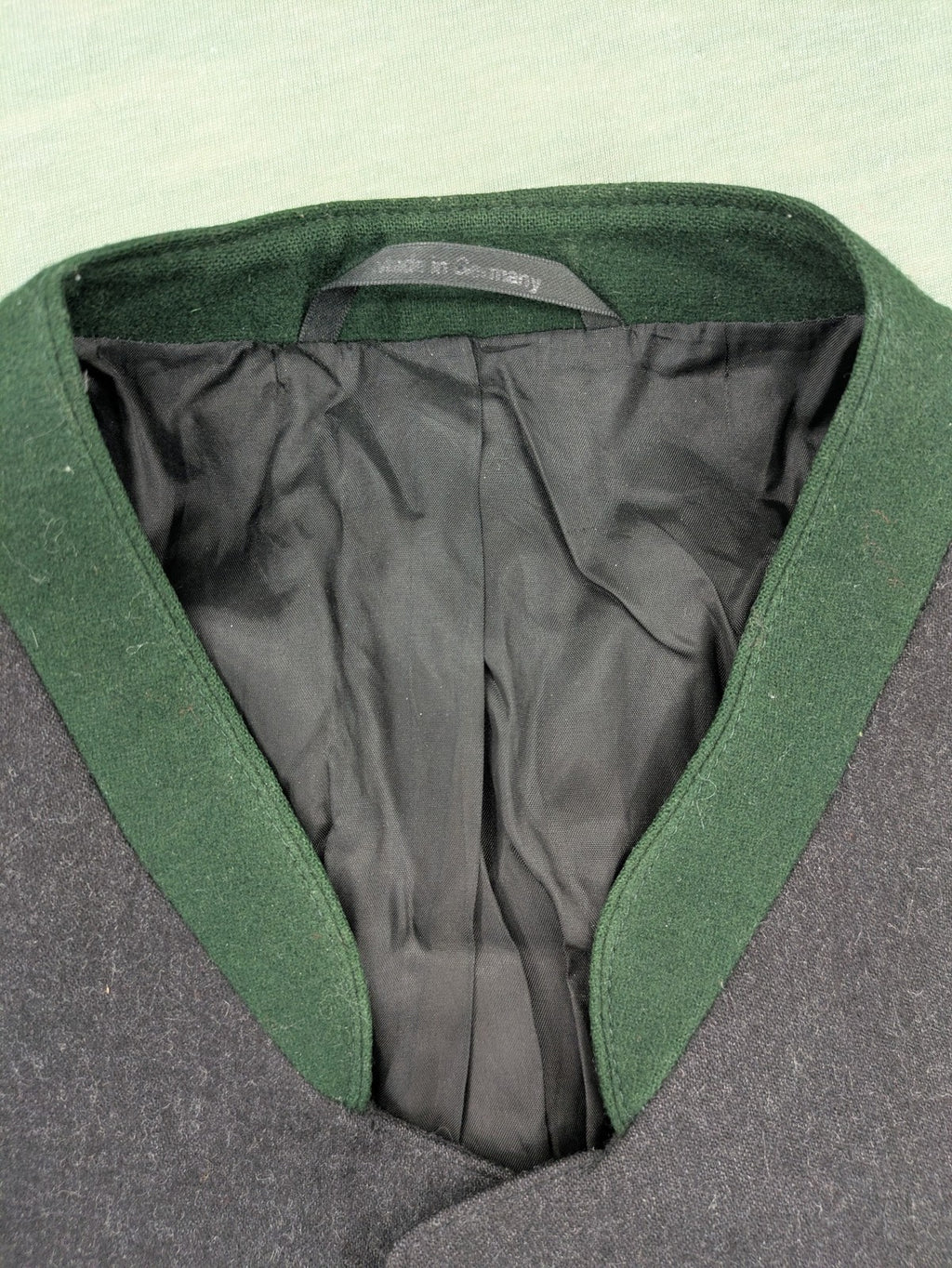 Rofan Tracht grey jacket with green stand-up collar and pockets, made from 100% wool.