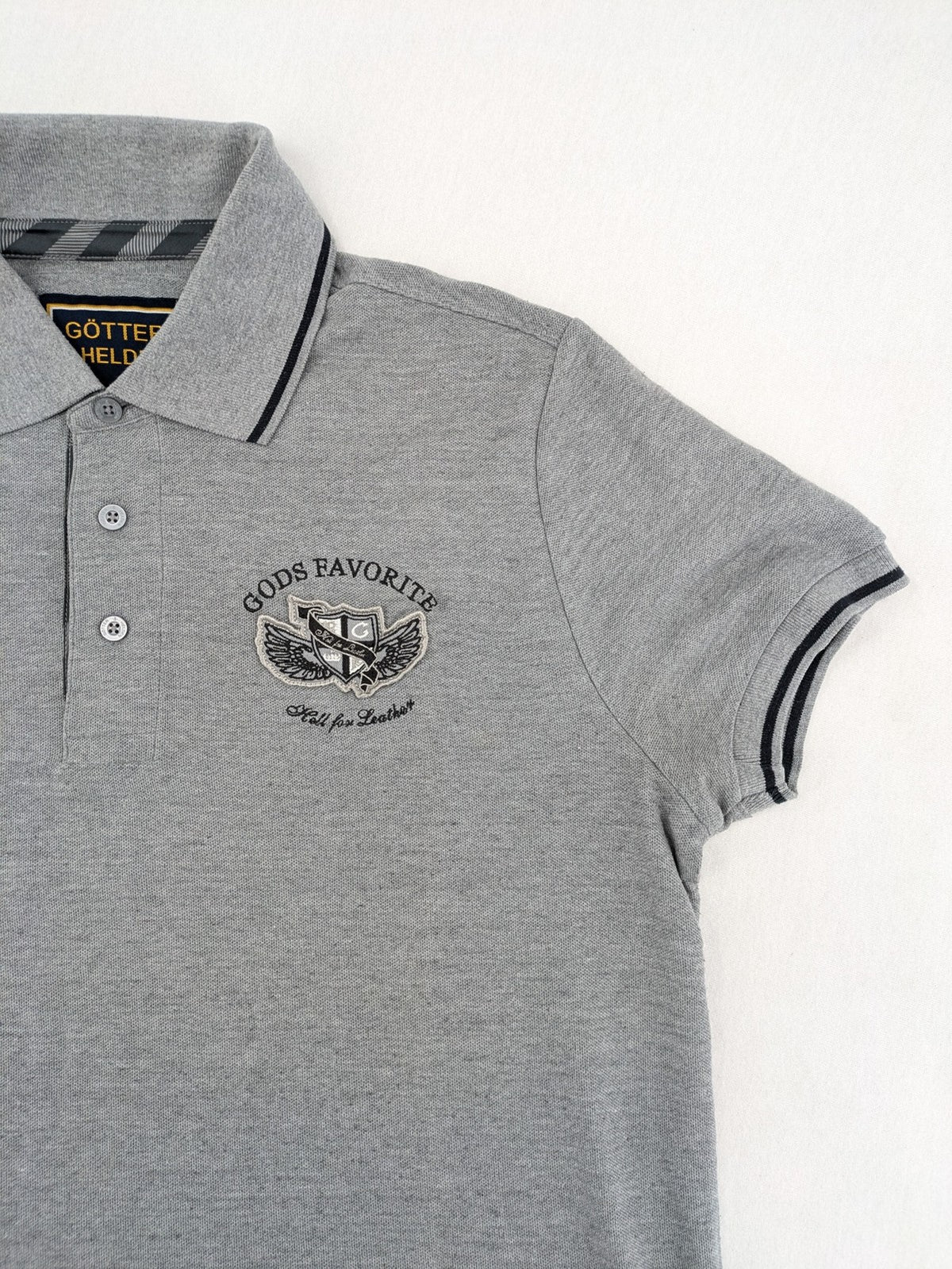 Götter & Helden grey polo shirt with "Gods Favorite" embroidery and contrasting collar details.