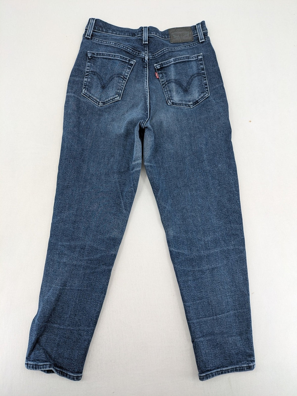 Levi's high waisted taper jeans dark blue 5-pocket design with zipper and stretch material.