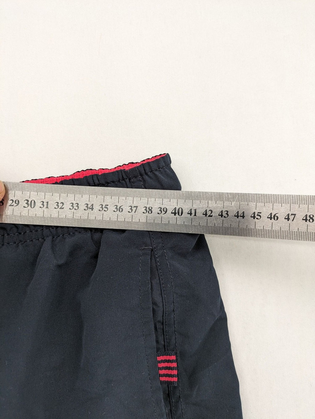 LC Waikiki navy swim shorts with red accents, elastic waistband, and quick-dry material.