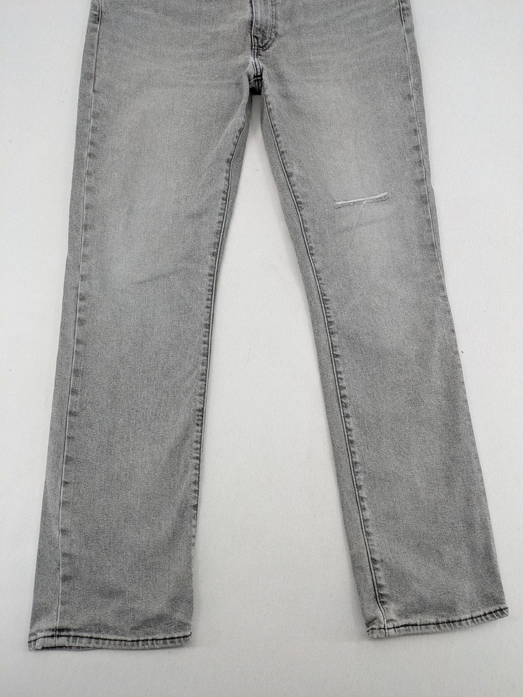 Levi's grey slim fit jeans with distressed knee details and classic logo patch.