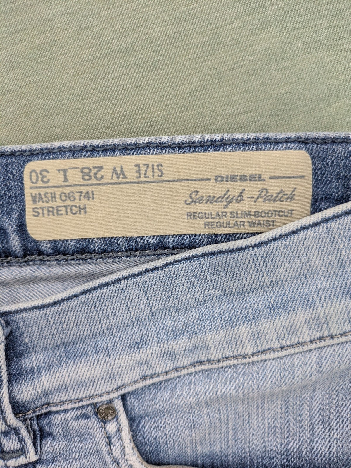 Diesel blue bootcut jeans with white patch pockets and regular waist, stylish stretch material.