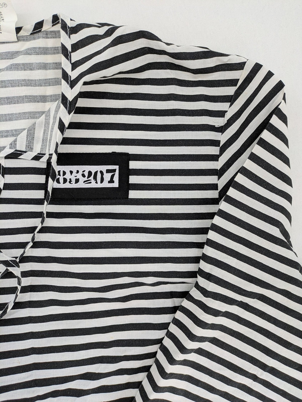 Rubie's costume set black and white striped with prisoner number patch on chest.