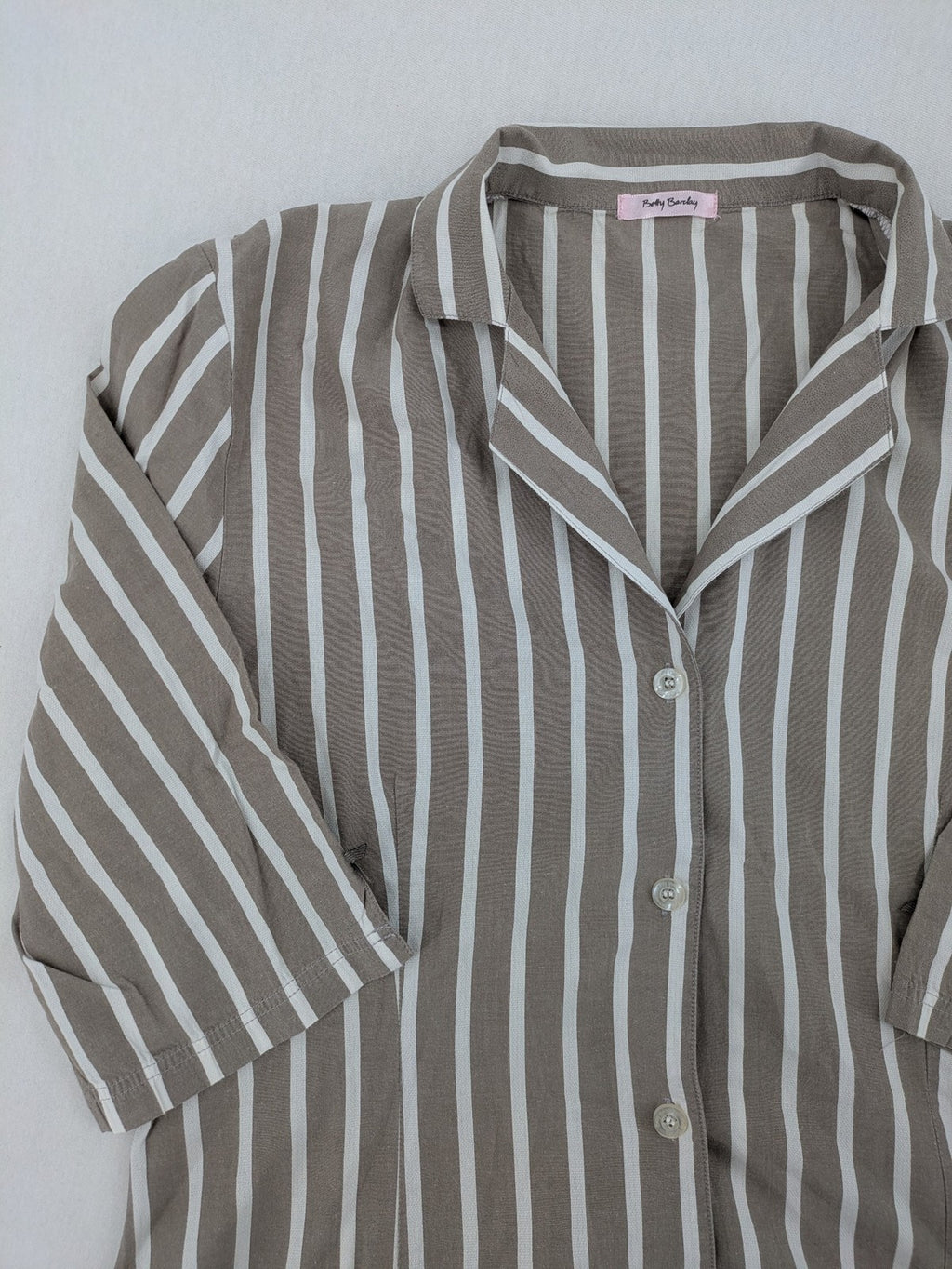 Body Sunday beige and white striped loungewear top with bow accents and button placket.