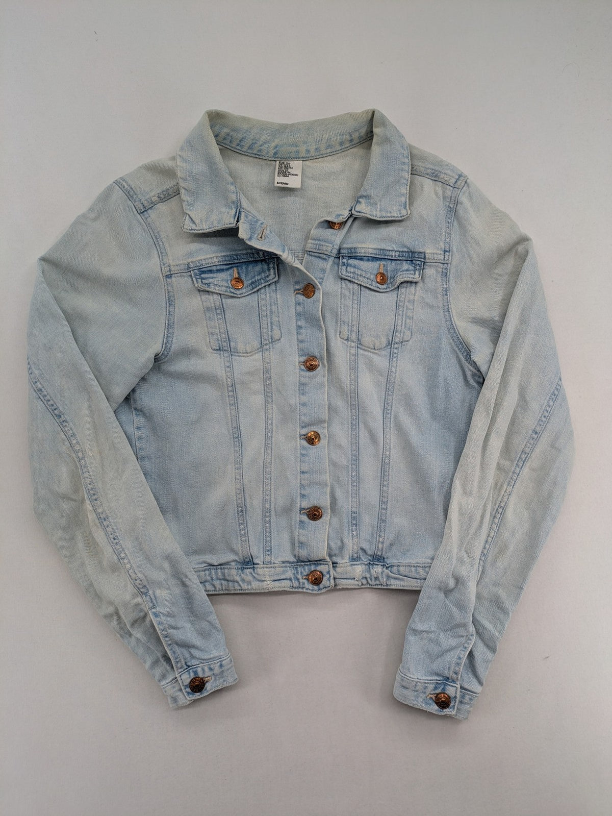 H&M denim jacket light blue classic trucker style with button placket and chest pockets.