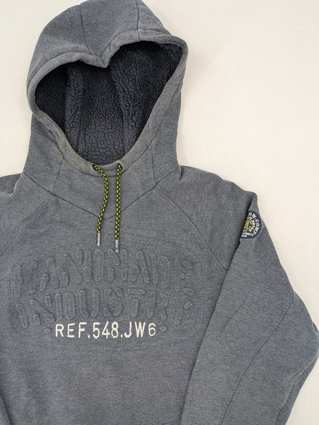 C&A grey hoodie with embossed chest logo, teddy-lined hood, and side zip pockets.
