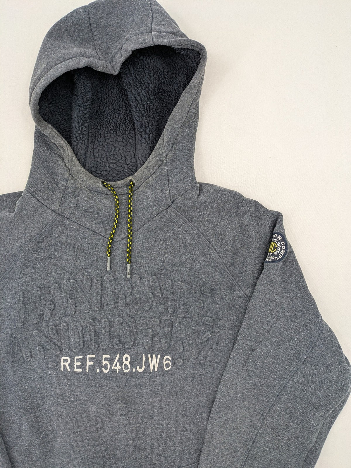 C&A grey hoodie with embossed chest logo, teddy-lined hood, and side zip pockets.