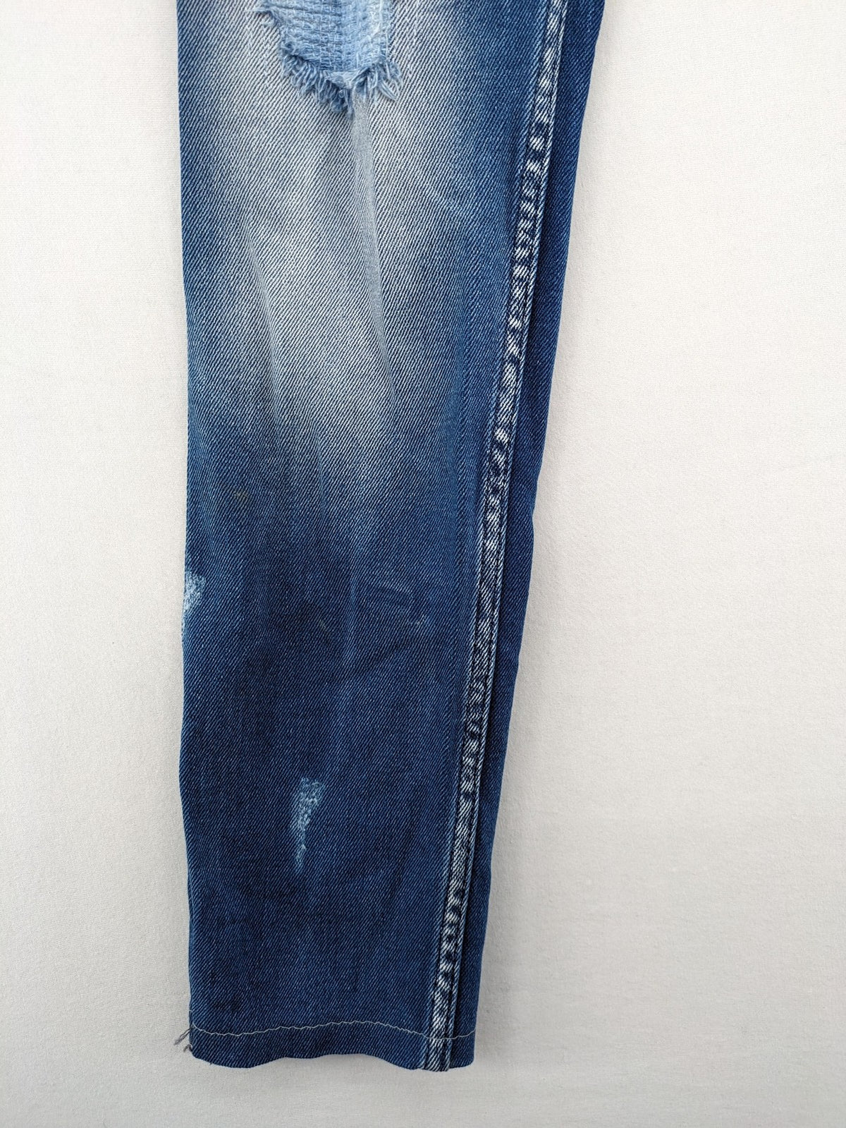 Diesel blue straight jeans with distressed details and ripped accents, made of cotton.