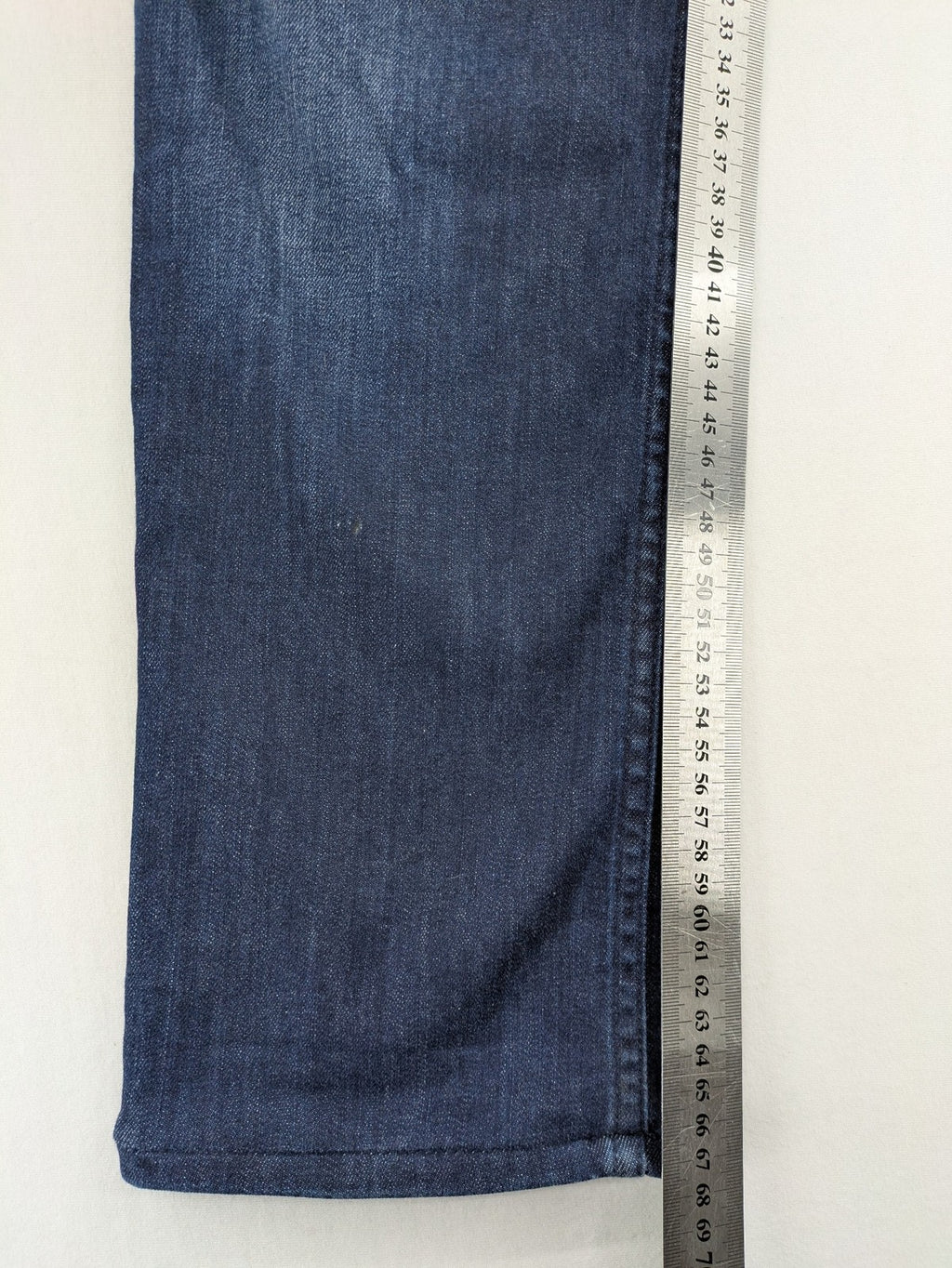 Tommy Hilfiger blue straight jeans with iconic logo and dark wash denim finish.