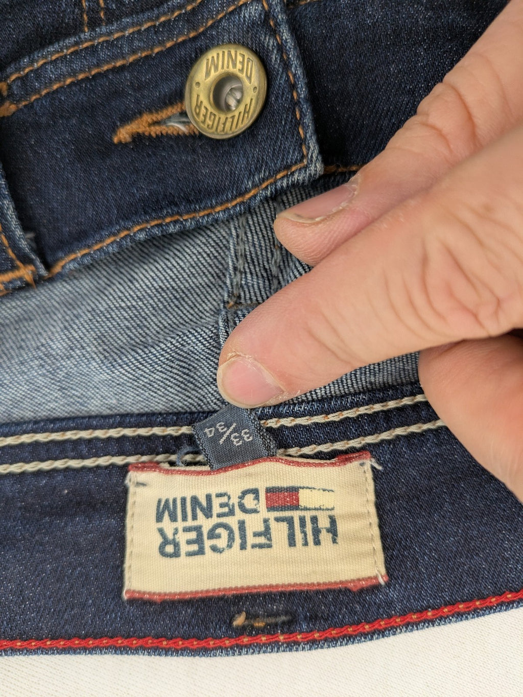 Tommy Hilfiger Denim blue straight jeans with five-pocket design and natural fading details.