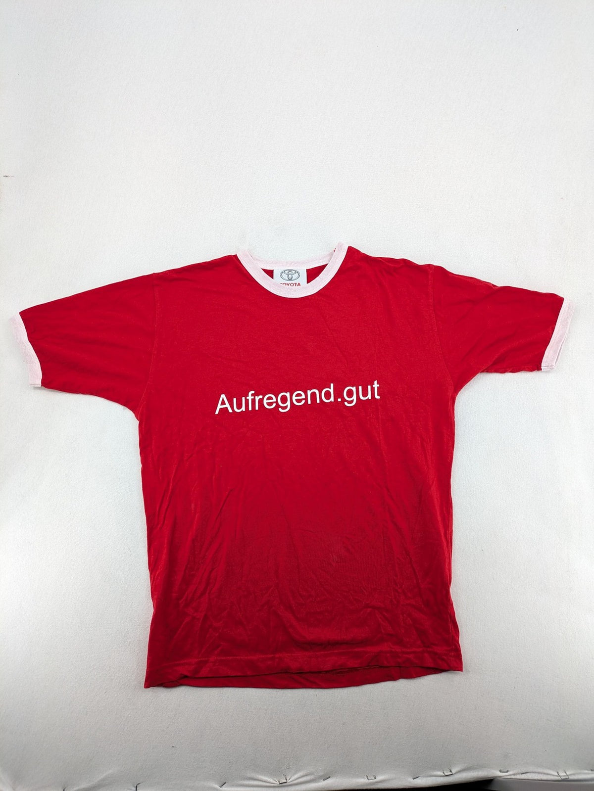 ck red Ringer T-shirt with white collar, "Aufregend.gut" slogan, 100% cotton.