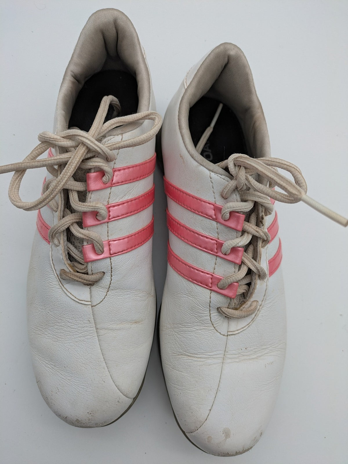 Adidas white golf shoes with pink stripes, Thintech and TRAXION technology, stylish design.