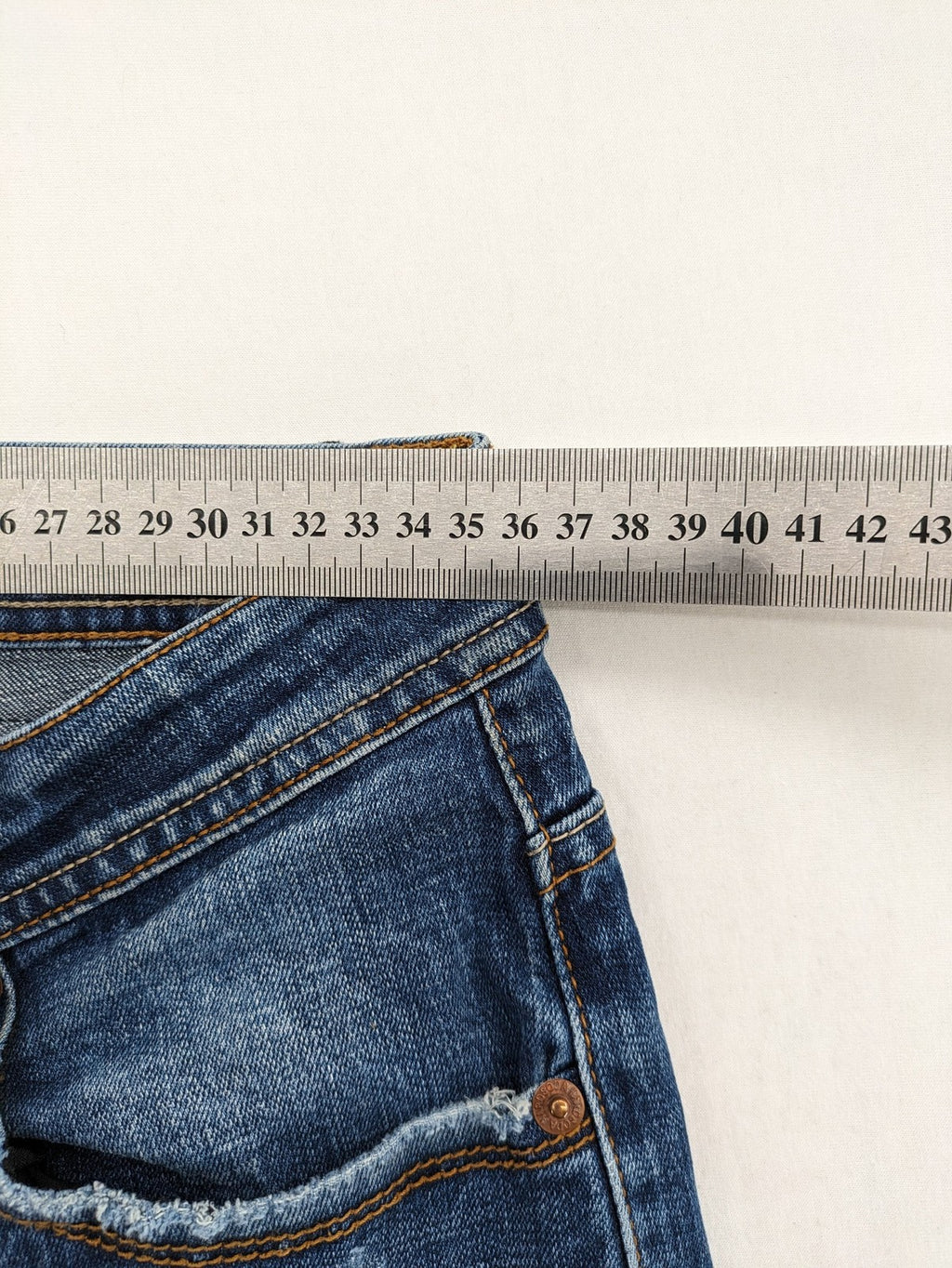 Soda blue straight jeans with distressed rips and button fly, cotton blend material.