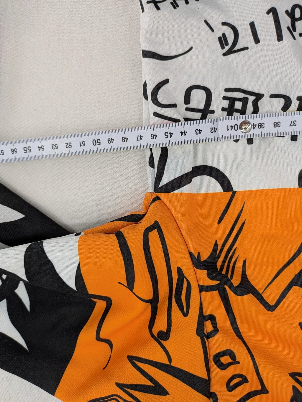 SHEIN orange zip-through hoodie with vibrant anime graphic print and colorblock design.