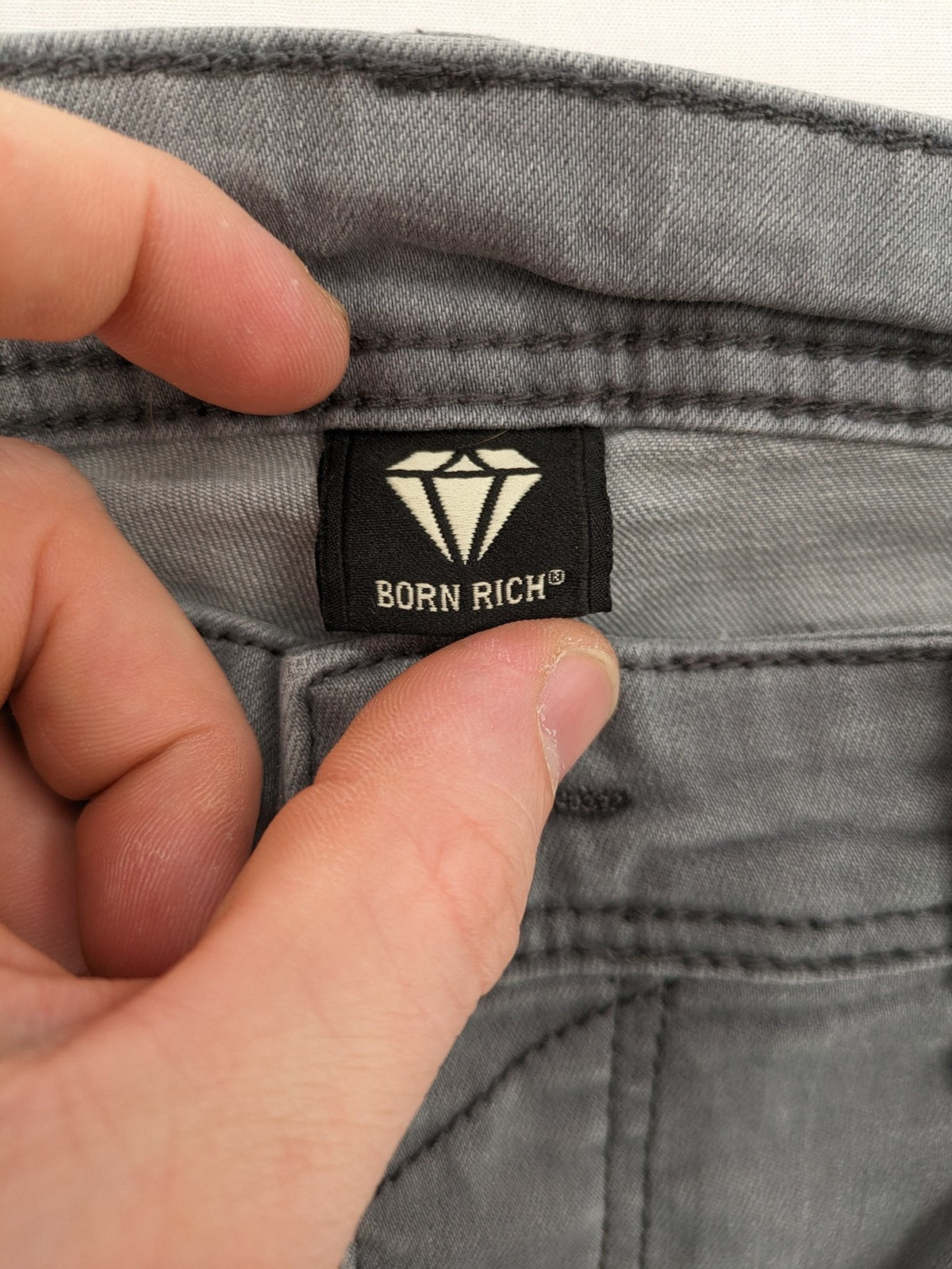 Born Rich grey slim fit jeans with logo patch and washed denim look.