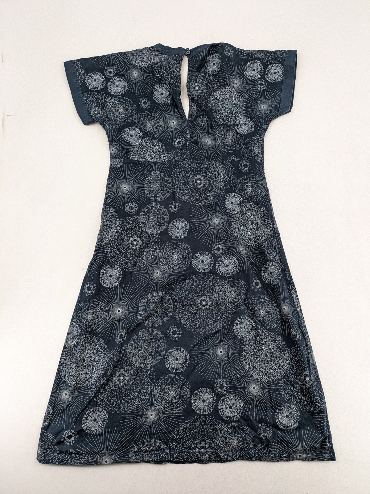 Muster navy dress with white abstract dandelion print, V-neck and collar details.