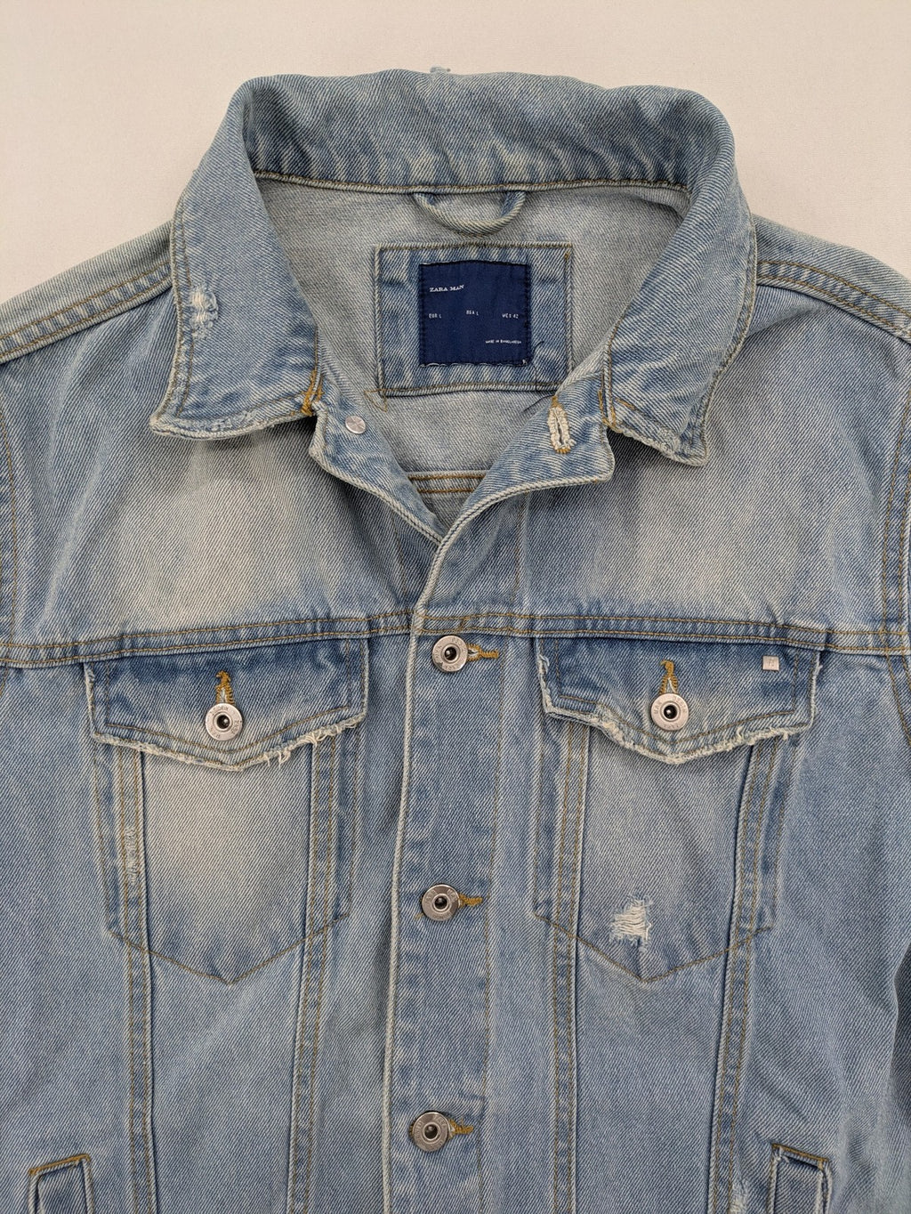Zara Man blue denim jacket distressed with button closure and chest pockets.