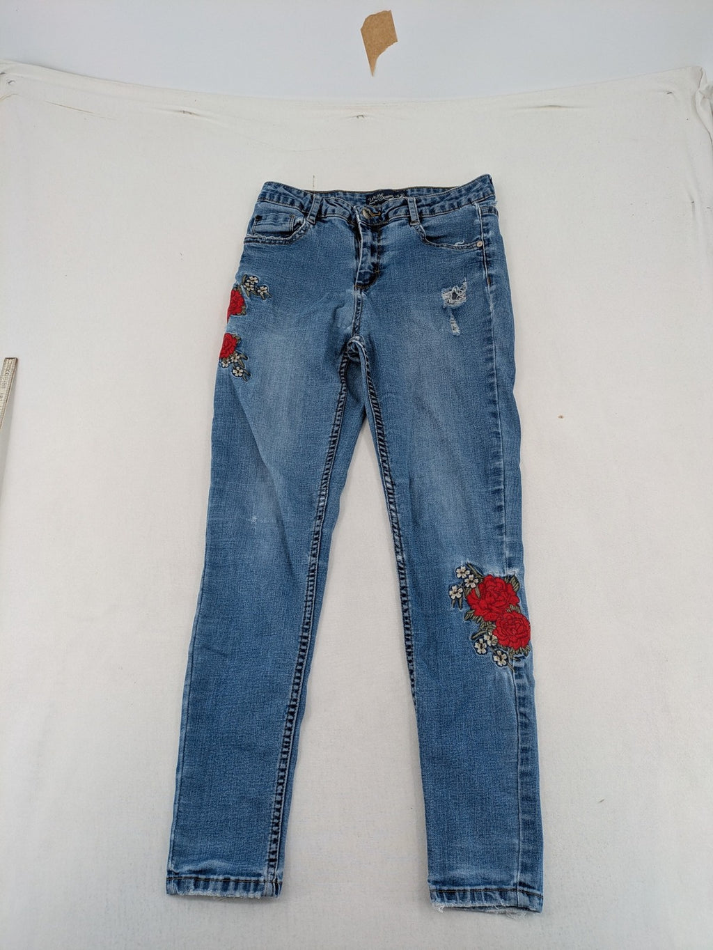Jennyfer pink skinny jeans with distressed details and red rose embroidery on hips and knees.