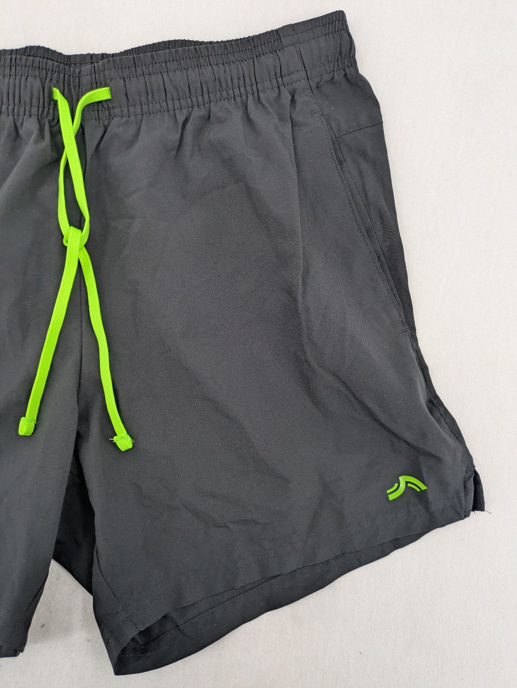 Crivit black running shorts with neon green accents, elastic waistband, and reflective details.