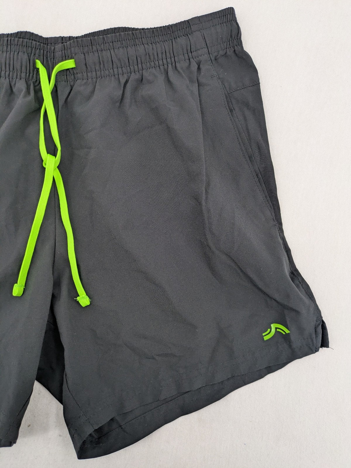 Crivit black running shorts with neon green accents, elastic waistband, and reflective details.