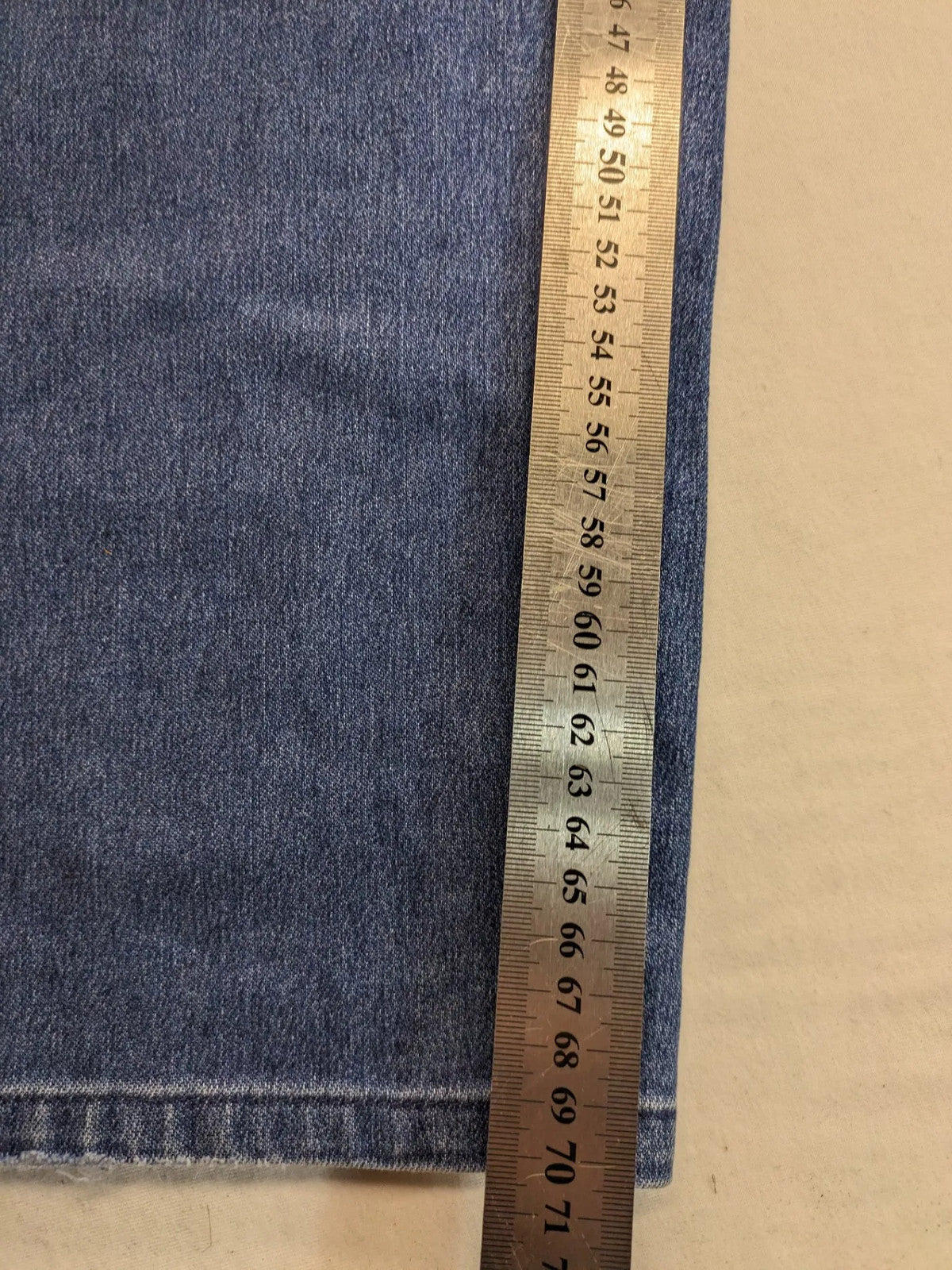 REI blue straight jeans with front pleats, zip fly, and buttoned back pockets.