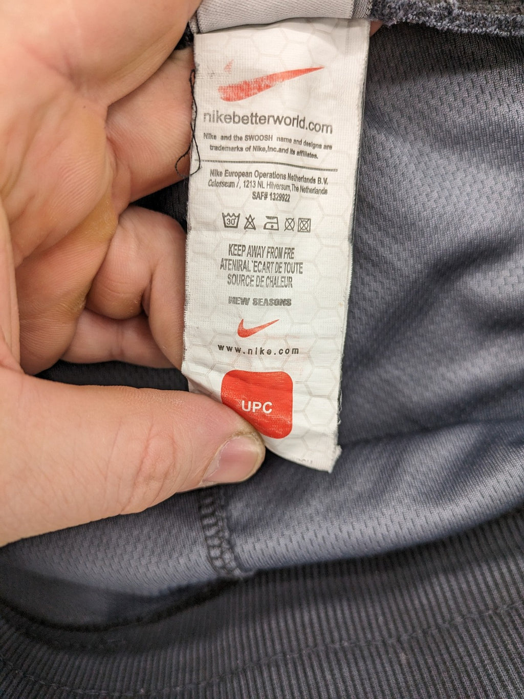 Nike F.C. grey jogger pants with elastic waistband, side pockets, and embroidered Swoosh logo.