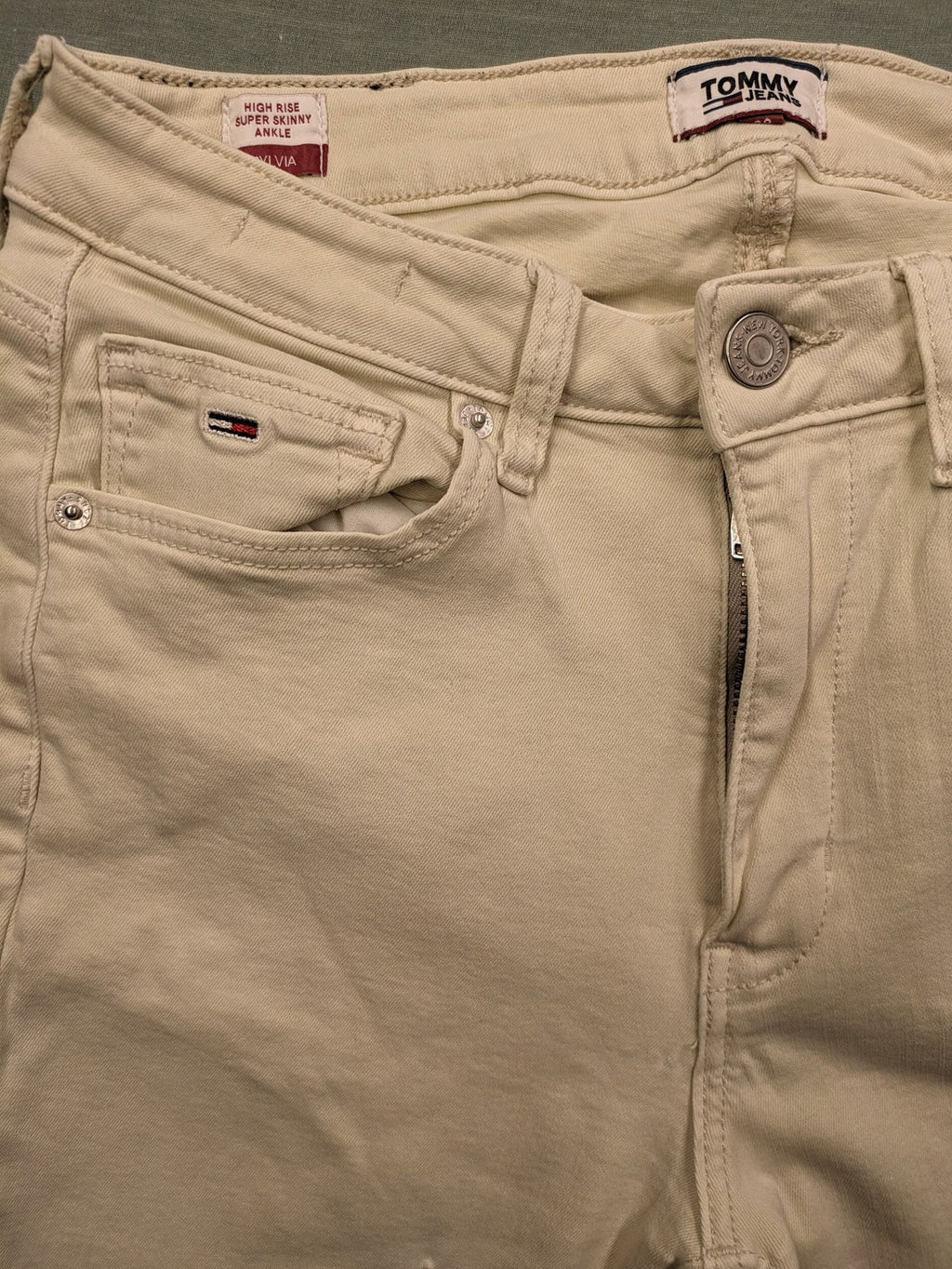 Tommy Jeans beige high rise skinny ankle jeans with logo patch and stretch fabric.