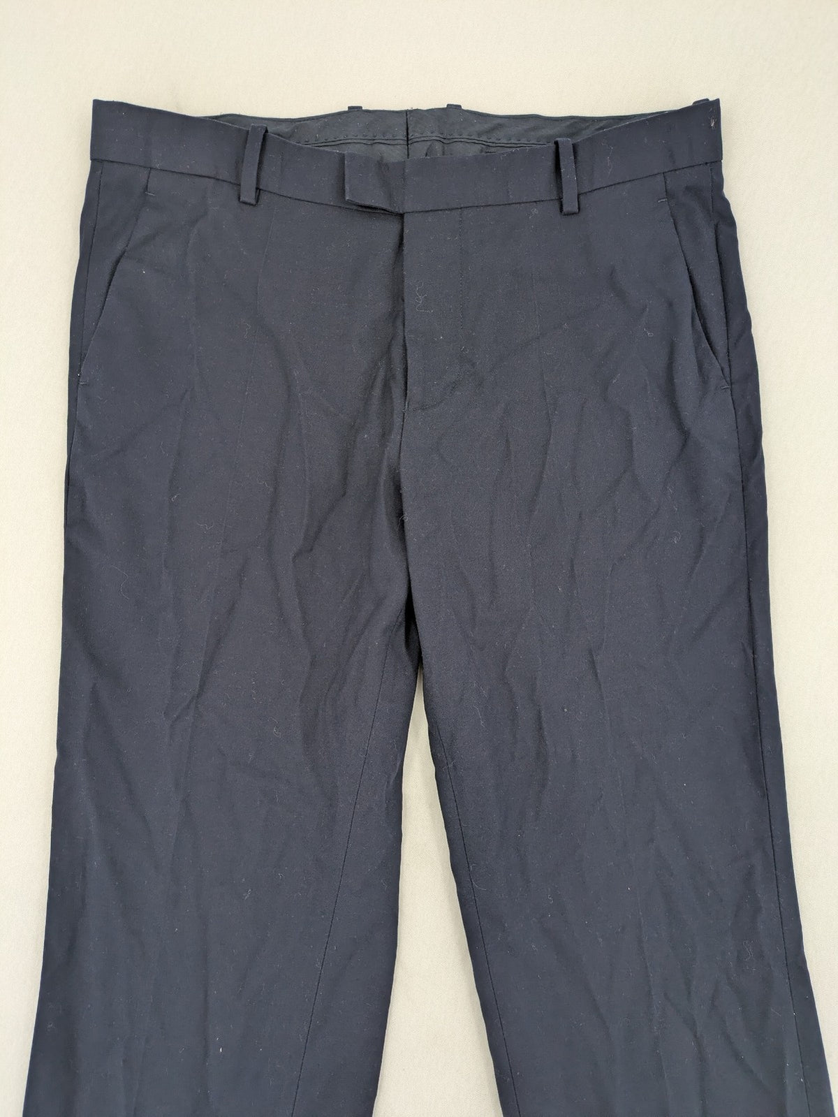H&M navy slim fit executive suit trousers with flat-front design and side pockets.