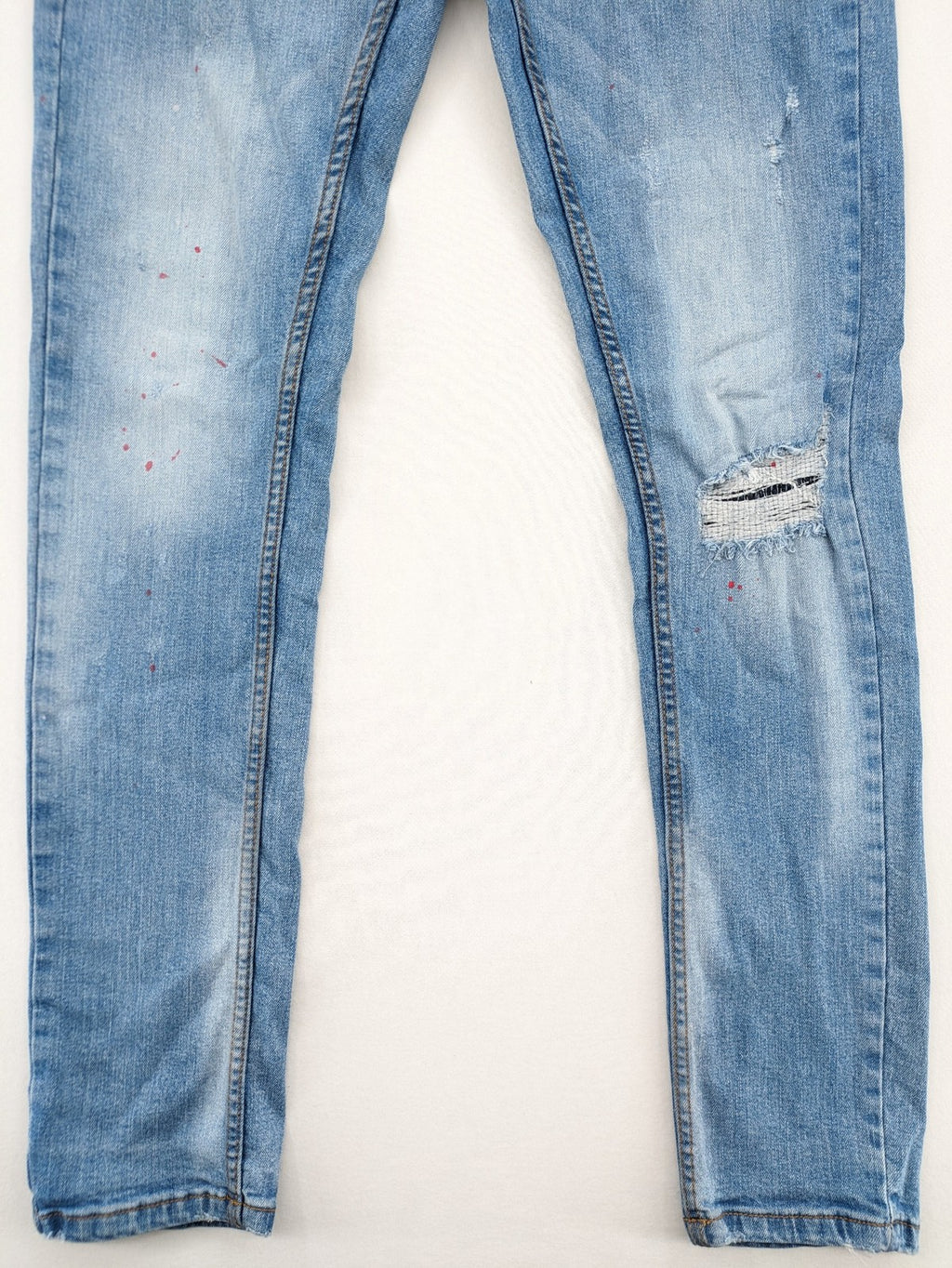 Milano straight jeans light blue distressed with red splatter and extra slim fit.