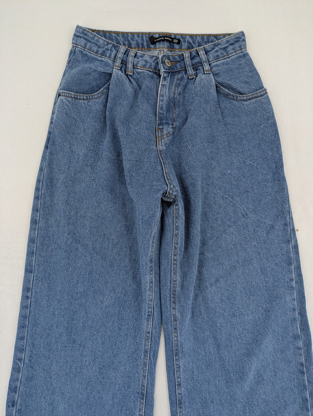 X.LOVE blue high waist wide leg jeans with front pleats and frayed hem.