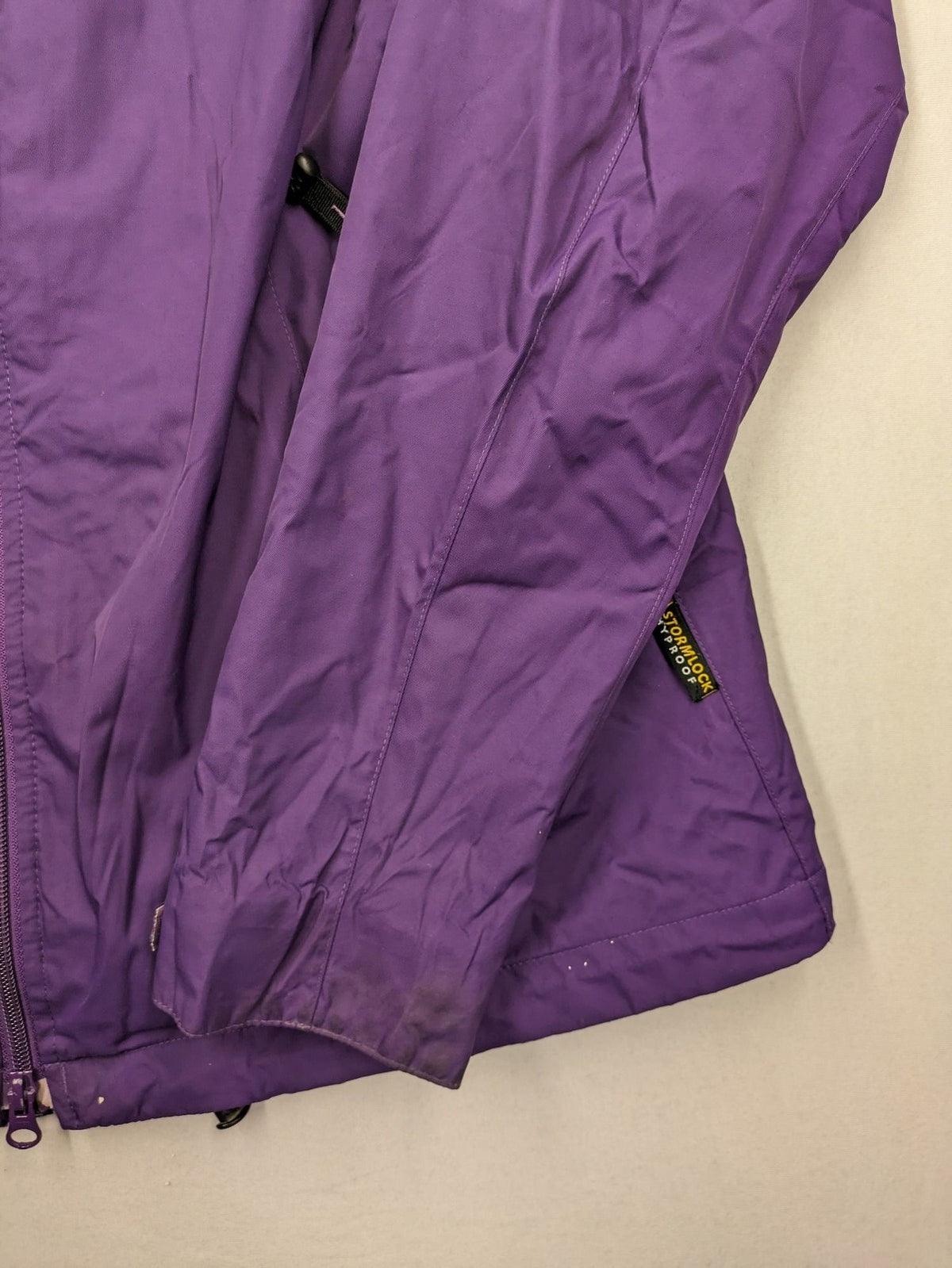 Jack Wolfskin purple outdoor jacket with adjustable hood and full zip, lightweight Stormlock material.