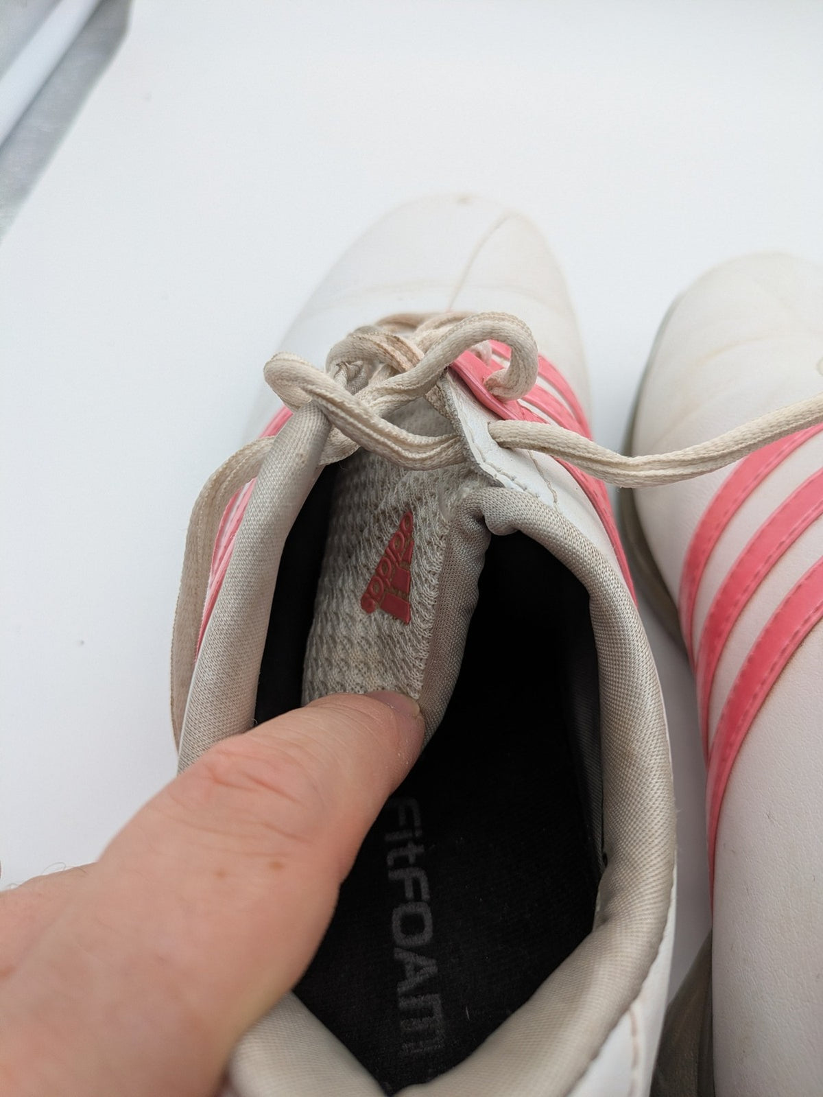 Adidas white golf shoes with pink stripes, Thintech and TRAXION technology, stylish design.