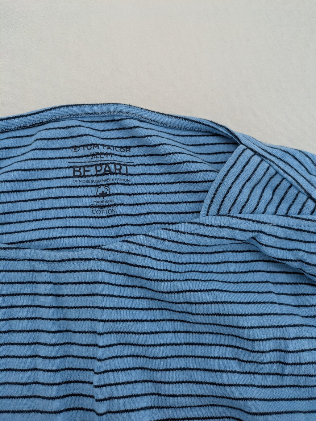 Tom Tailor blue striped top with gold heart emblem, made from organic cotton.