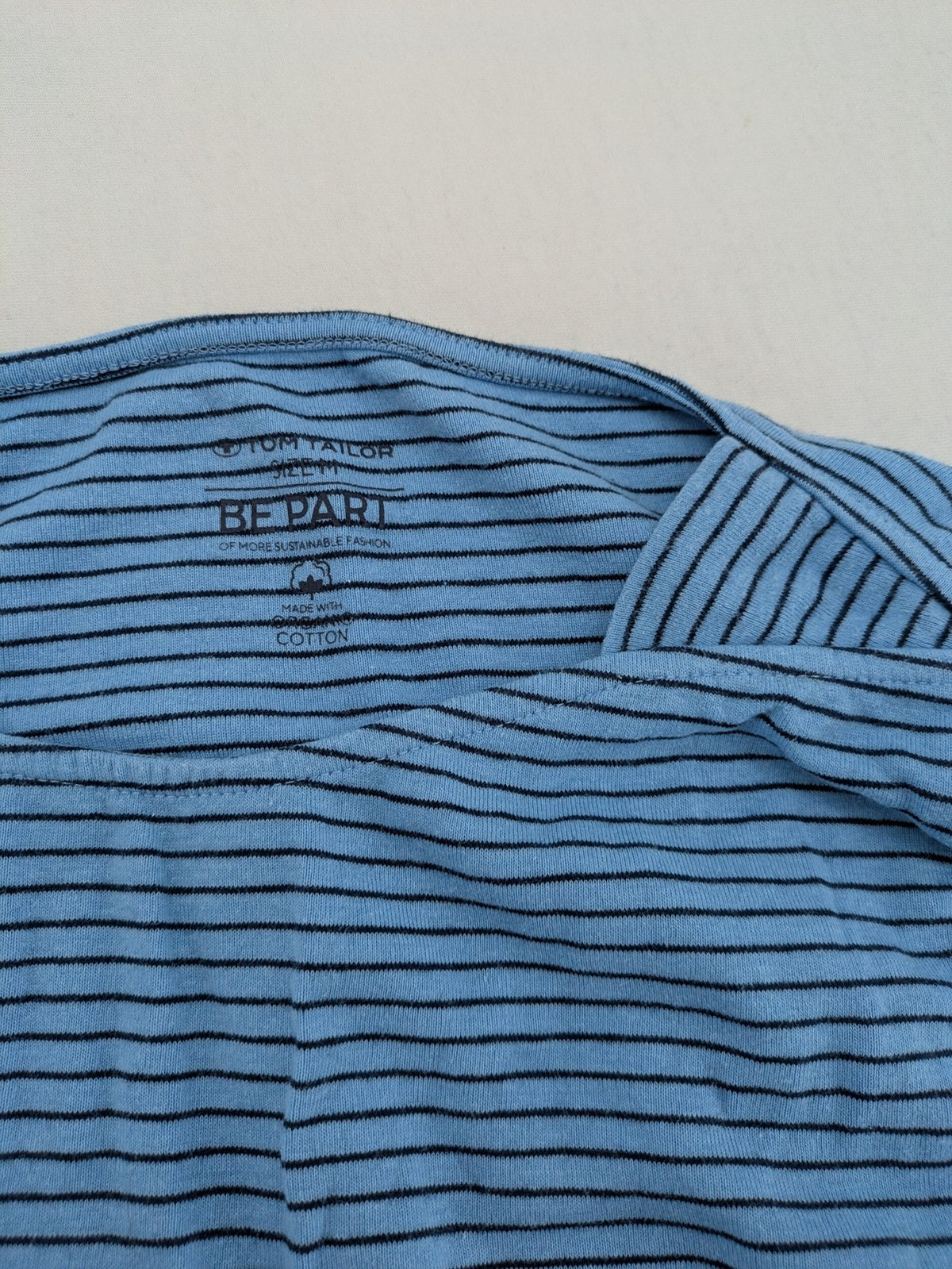 Tom Tailor blue striped top with gold heart emblem, made from organic cotton.