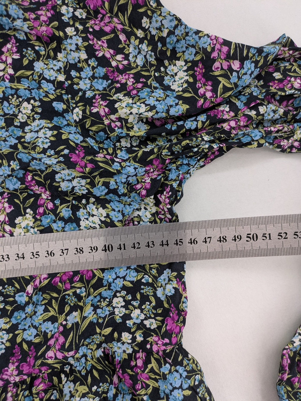 Zara multi-coloured floral mini dress with classic collar and button placket on black background.