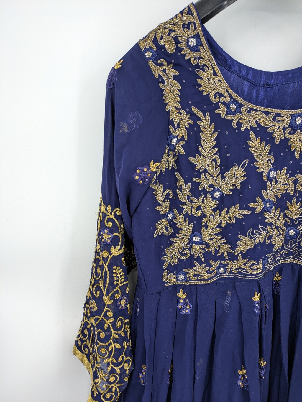 Bollywood bridal party dress gold with intricate blue embroidery and flowing Anarkali silhouette.