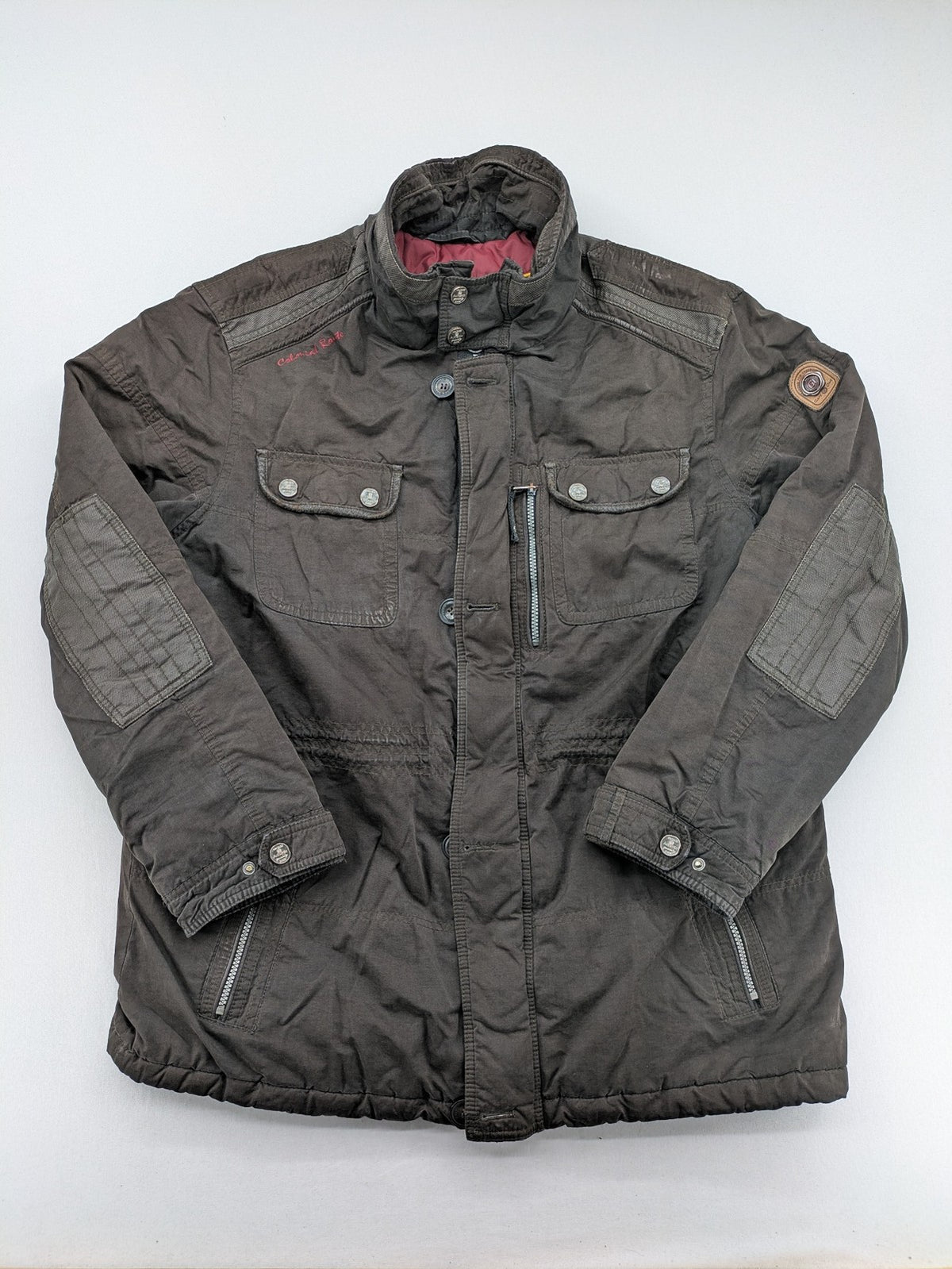 Gate One brown field jacket with plaid lining, multiple pockets, and zip-button closure.