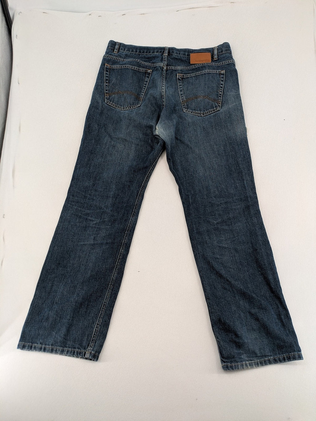 Indygo blue straight jeans 5-pocket style with subtle red pocket detail, cotton material.