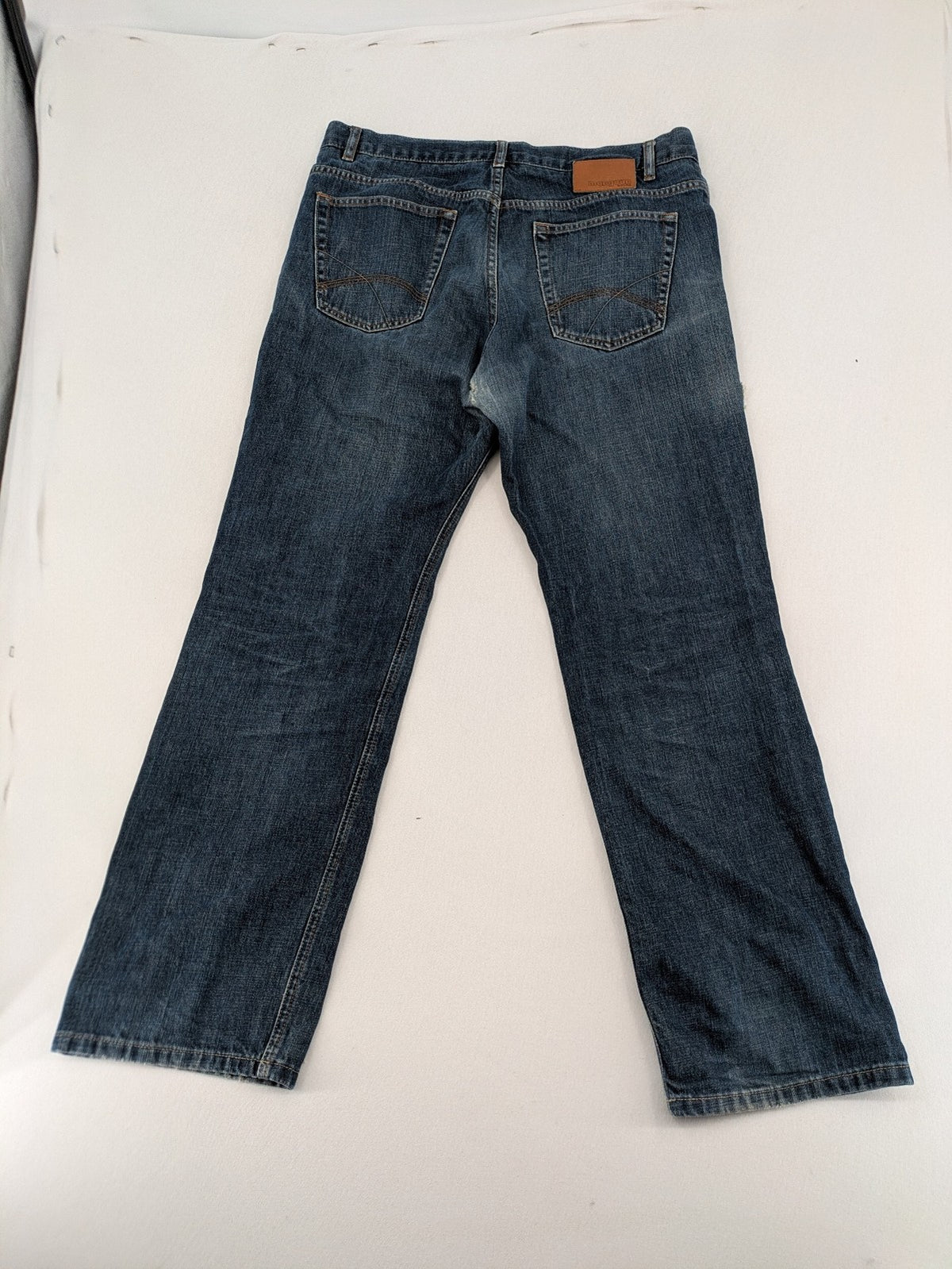 Indygo blue straight jeans 5-pocket style with subtle red pocket detail, cotton material.