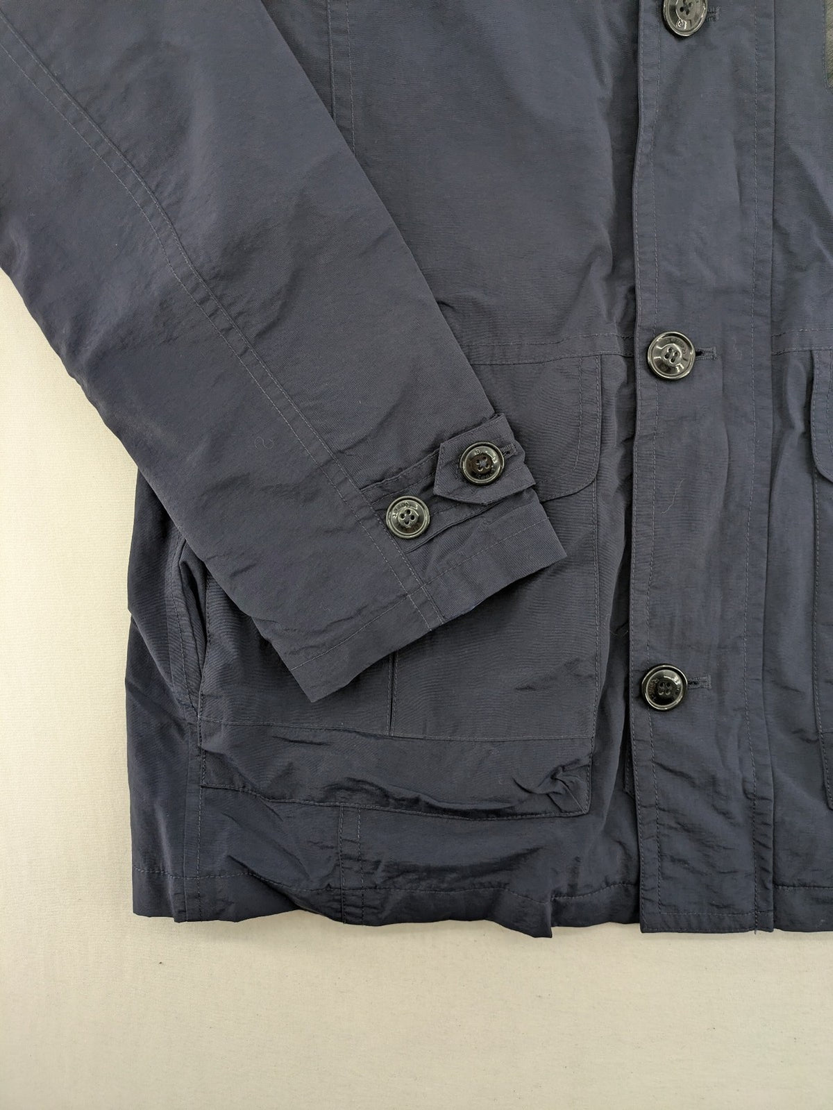 Reset navy parka jacket windproof with adjustable hood and zippered chest pocket.