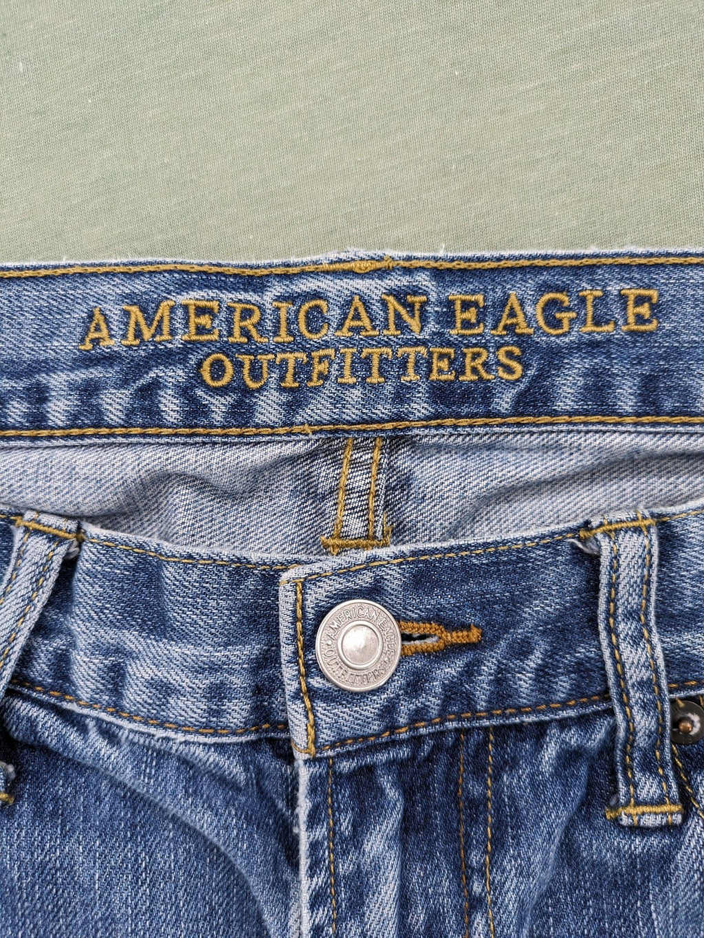 American Eagle Outfitters blue straight jeans with distressed detailing and classic five-pocket design.