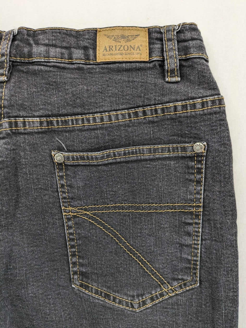 Bootcut grey low rise bootcut jeans five-pocket design with zipper and button closure.