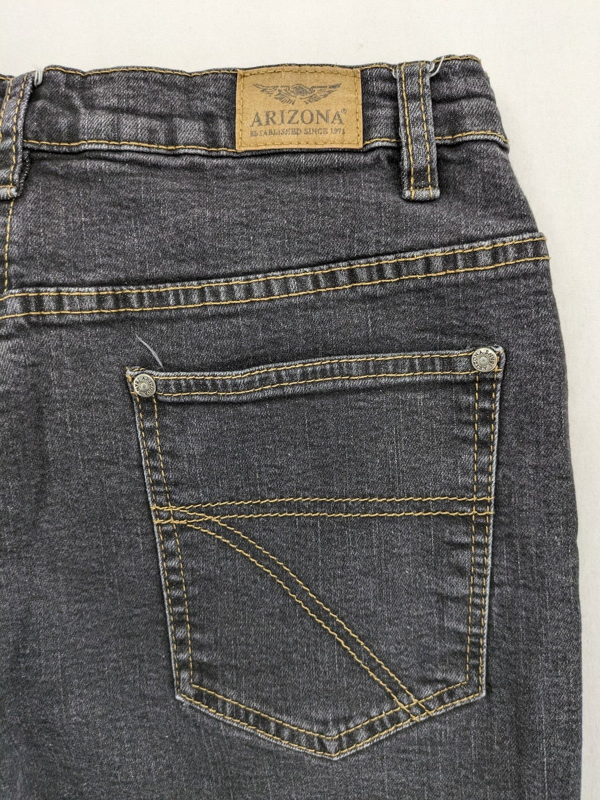 Bootcut grey low rise bootcut jeans five-pocket design with zipper and button closure.