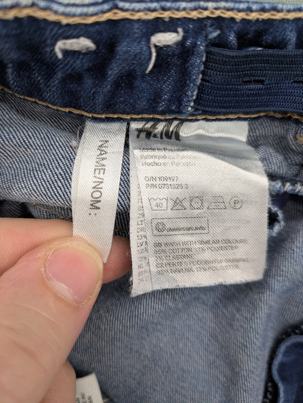 H&M blue skinny jeans with distressed knee details and classic 5-pocket design.